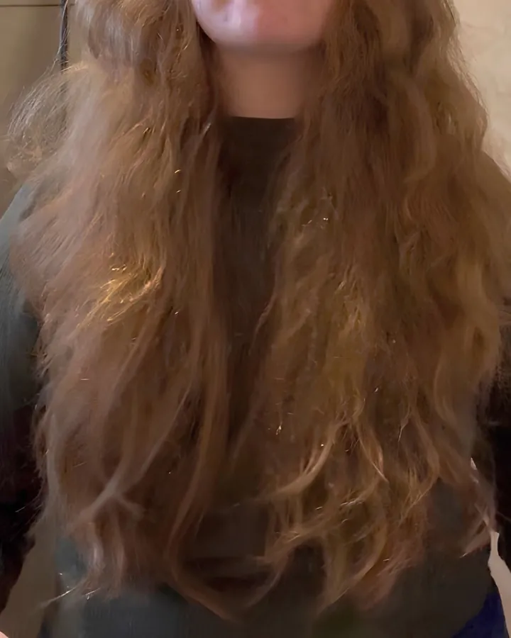 Cabelo ondulado longo com frizz acentuado e fios soltos ao redor do comprimento.